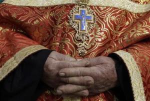 A Greek Orthodox priest waits for the Eastern Orthodox Christmas procession outside the Church of the Nativity in Bethlehem